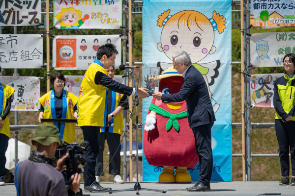 熊本県大津町町長から伝統工芸「梅の造花」を大津市長に手渡す様子