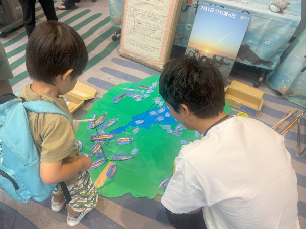 わくわく体験ブース「びわ湖の日」にちなんでびわ湖の魚の釣りにチャレンジする子どもの様子