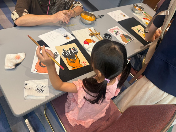わくわく体験ブース「ヨシ紙に大津絵を描いてみよう」でヨシ紙に大津絵を描く子どもの様子