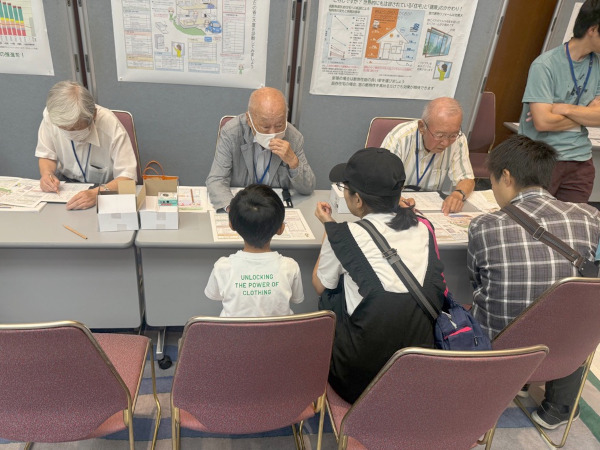 わくわく体験ブース「あなたのおうちの省エネは?」で省エネについて考える親子の様子