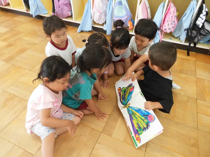 3歳の子ども達が友達と一緒に絵本を読んでいるところ