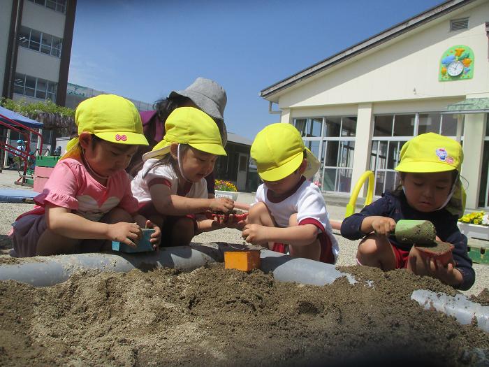 子ども達が砂場で遊んでいるところ