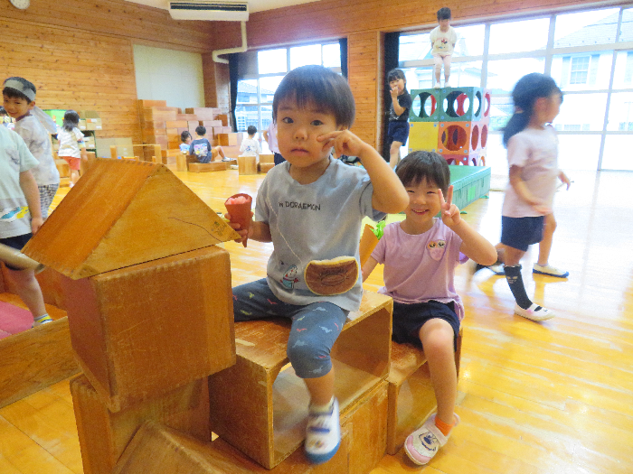 積み木で作ったドラゴンに男の子と女の子が乗っている