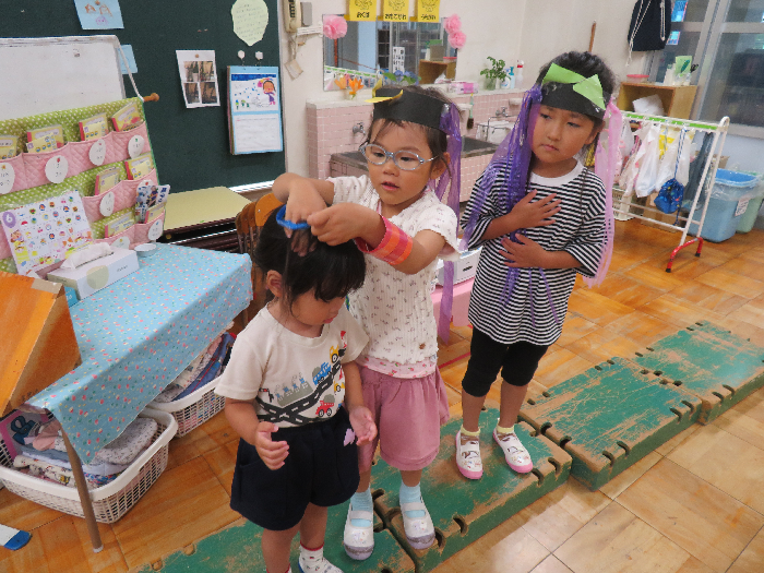 女の子がお面をかぶせてあげている