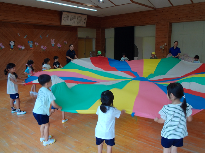 5歳児が演技用のカラフルなバルーンをもって広げている