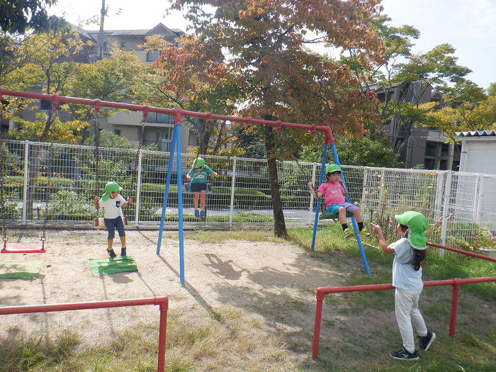 友達とブランコに乗る子どもの様子