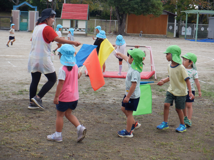 カラフルな旗を持って友達と踊っている様子