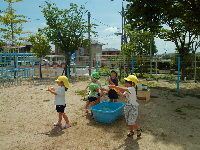 園庭で水鉄砲をしている園児5人
