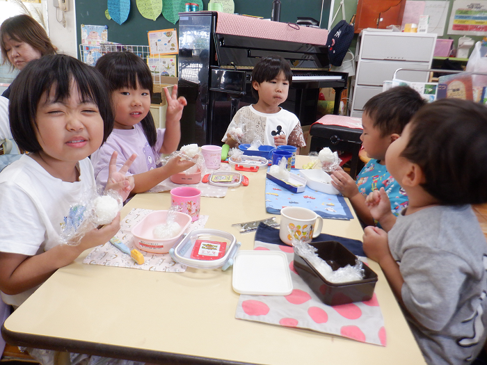 おにぎりを食べてピースをしている子ども達
