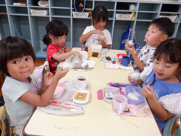 おにぎりをほうばって食べている子ども達
