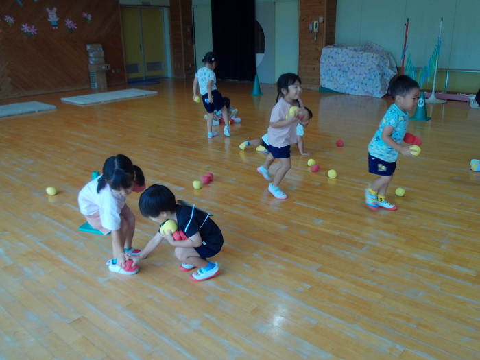 3歳児が小さな玉集め遊びをしている