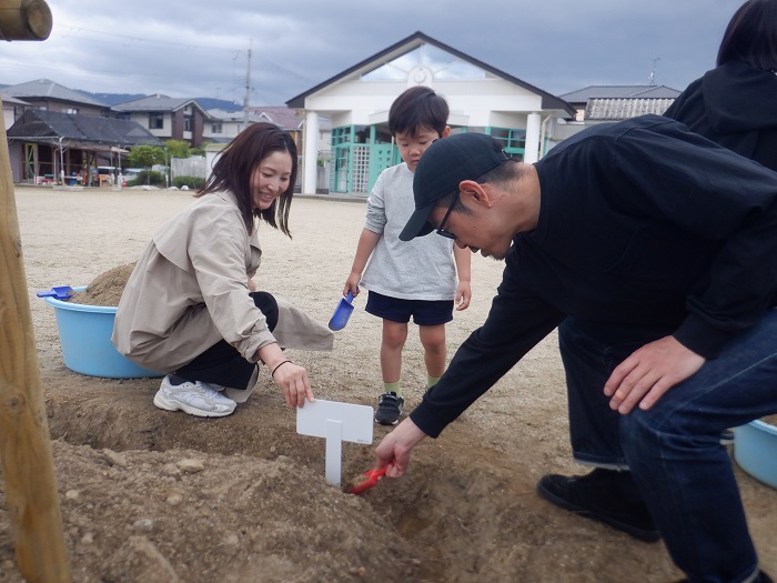 親子で桜のプレートを立てている様子