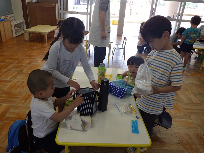 お弁当の準備を手伝う5歳児の様子