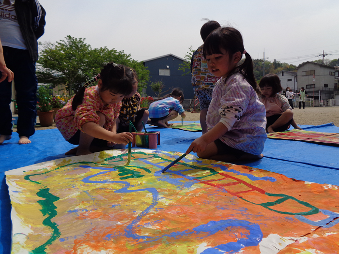 外で絵の具遊びをしている子ども達の様子