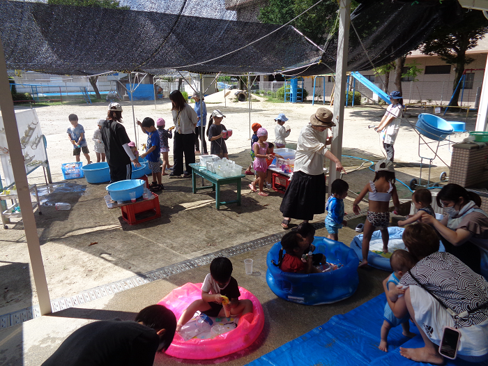 未就園活動くりっこひろば、一時預かり保育の子どもと一緒に水で遊ぶ様子