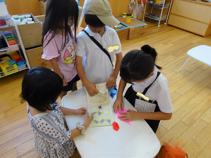 折り紙を教えてもらっている様子