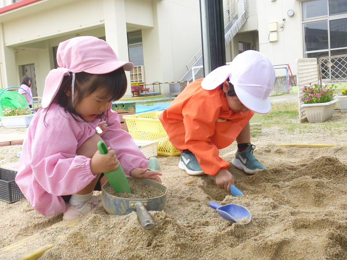 砂場遊びをする3歳児の様子