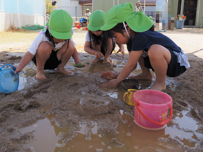 泥遊びをする4歳児