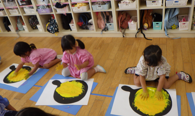 絵具遊びをする3歳児の様子