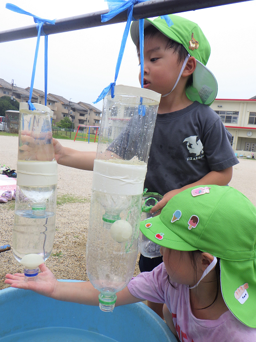 ペットボトルに水を入れる4歳児の様子