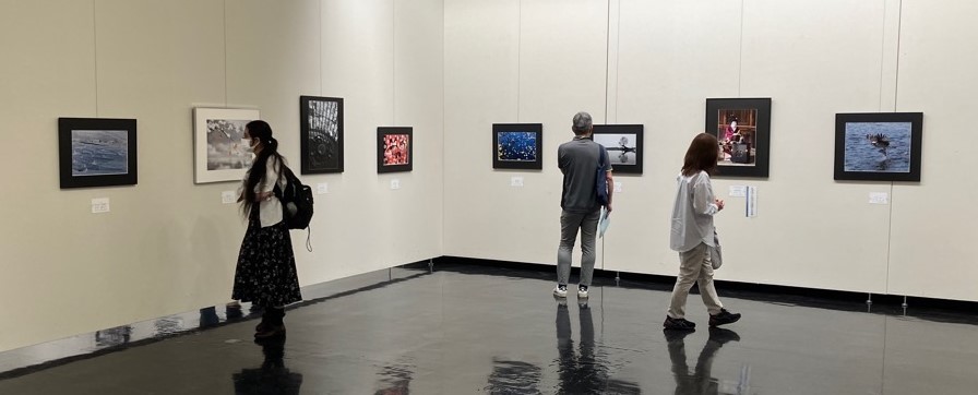写真展覧会で写真を鑑賞する観客の様子