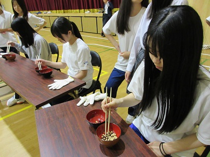 軍手着用時と比較しながら豆をとなりの椀に移す