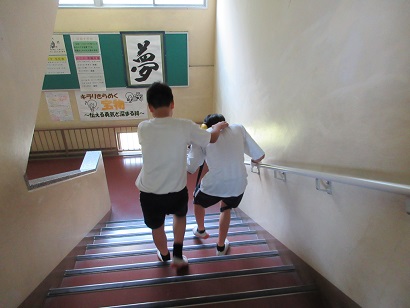 体験グッズを着用し階段を下りる生徒