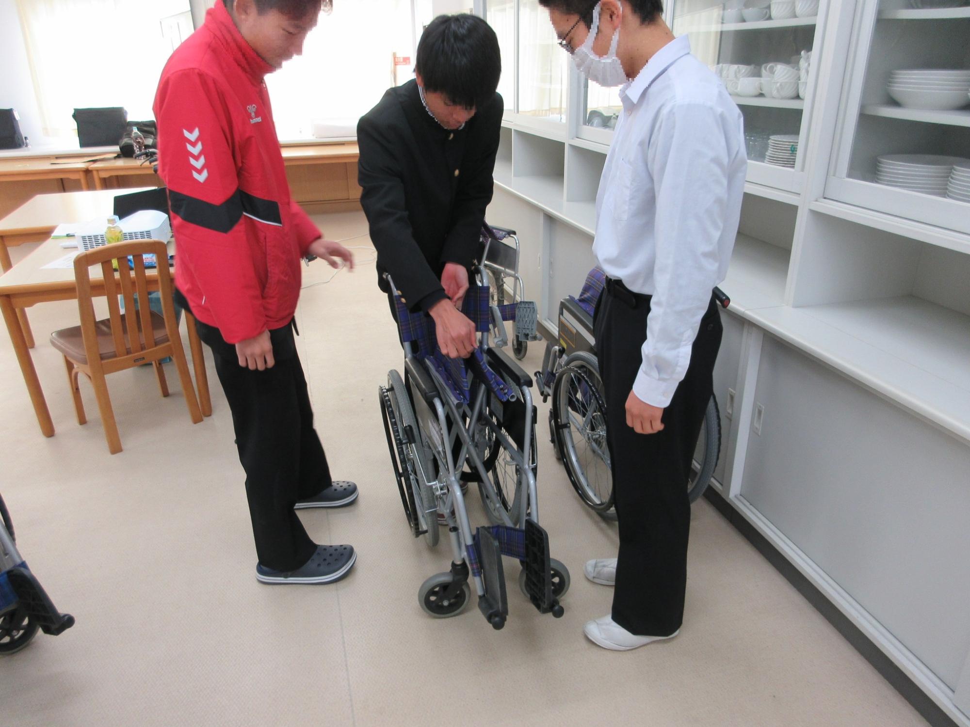 車椅子のたたみ方を体験する様子