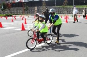 子どもが自転車に乗る練習をしている写真