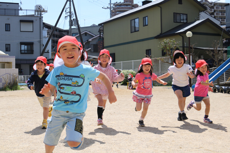 園庭を駆け回る子供たちの写真