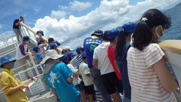 琵琶湖での採水の様子を見守る団員の様子