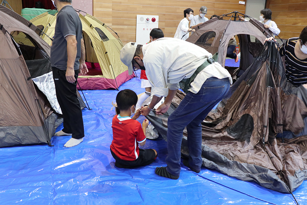 住民の皆さんが体育館の避難所運営でテントを建てる様子