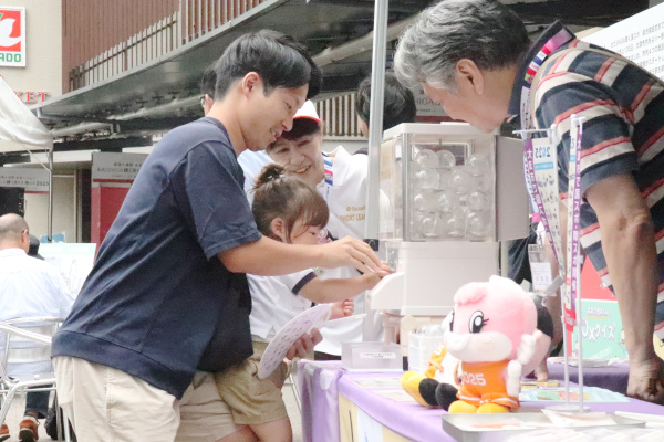 カプセルトイをする親子の様子