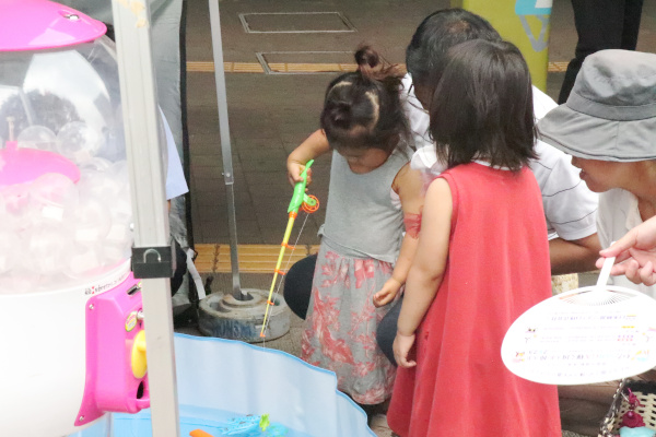 ベビープールに入った魚のおもちゃを釣る女の子の様子