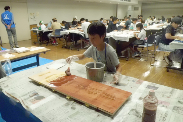工作体験　東海道統一案内看板にベンガラを塗る様子
