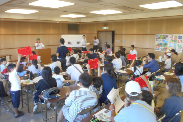 クイズ大会、参加者が回答ボードをあげる様子