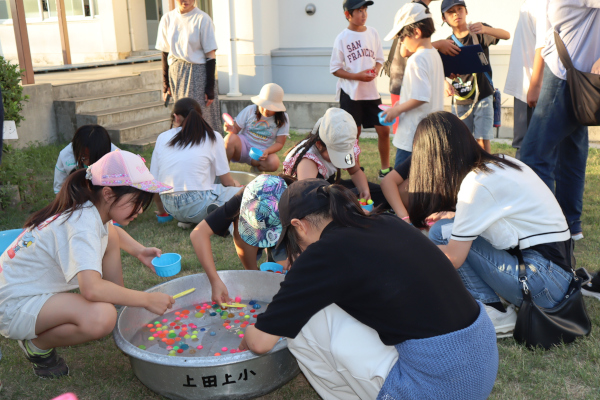 高学年の有志によるスーパーボールすくいを楽しむ子どもたちの様子