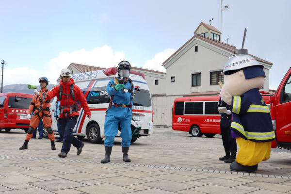 消防車両装備披露、おおつ光ルくんと一緒に装備のデモンストレーションをする隊員の様子