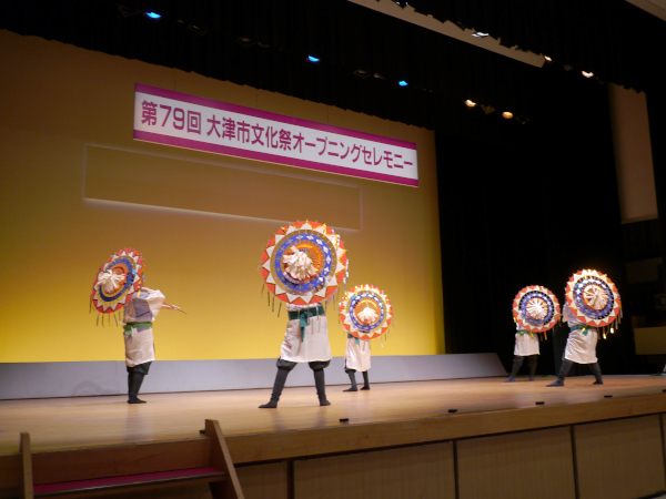 ステージで傘を使って民踊を披露する様子