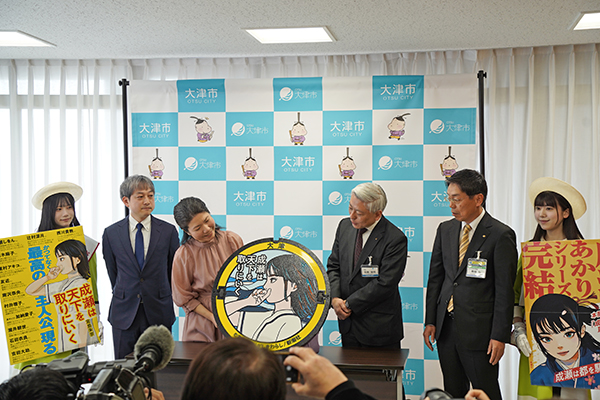 寄贈されたマンホールをのぞき込む宮島さんと佐藤市長（写真）