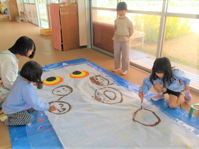 鯉のぼり祭りに向けてこいのぼりに絵をかく様子