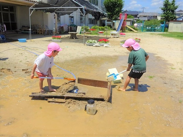 砂や水で遊ぶ4歳児