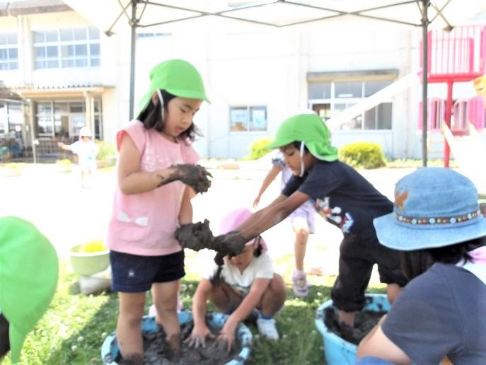 田んぼの土をこねる5歳児