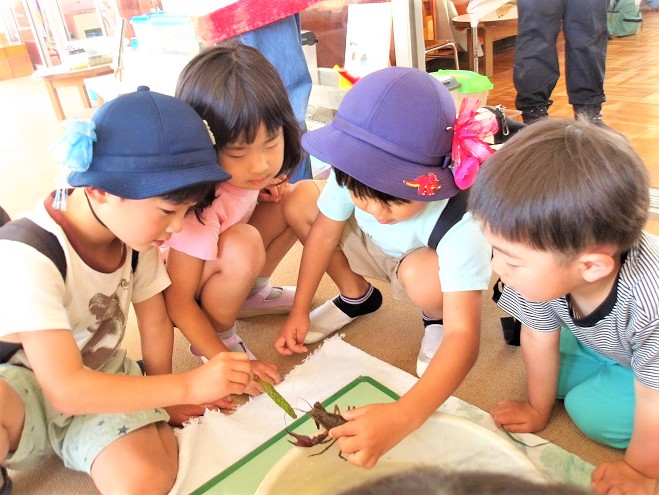 ザリガニをみる子どもたち