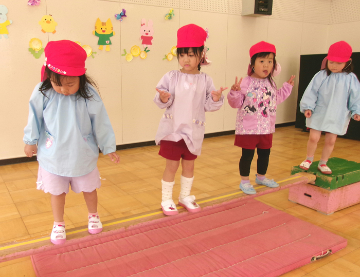 4歳児がカニの真似をしながら一本橋を渡っているところ