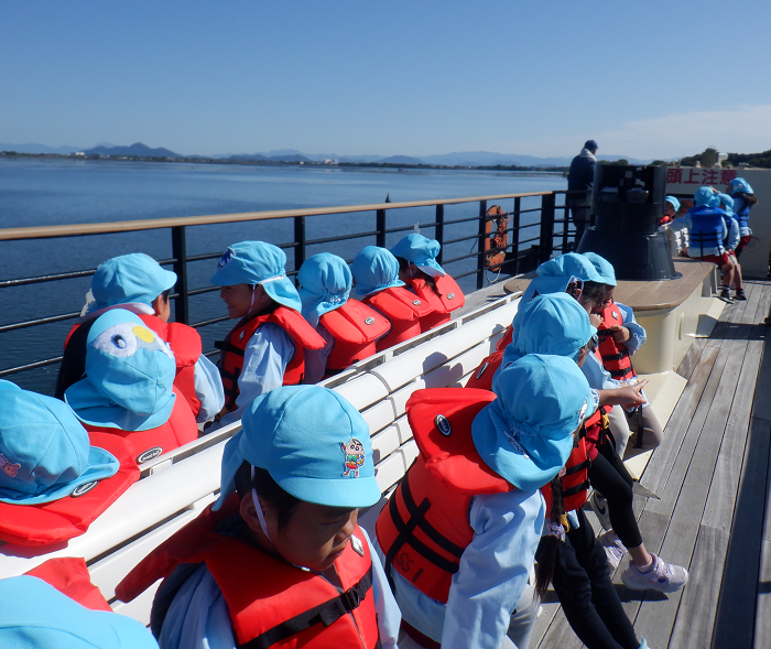 5歳児が船のデッキで座っているところ