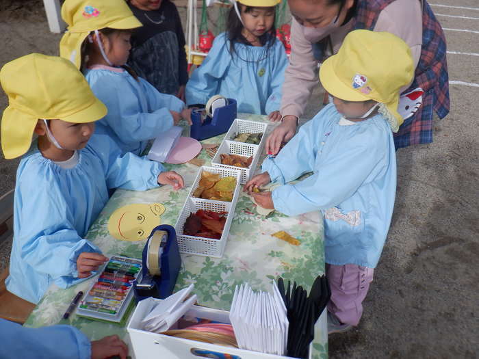 3歳児が落ち葉を使った製作をして遊んでいるところ