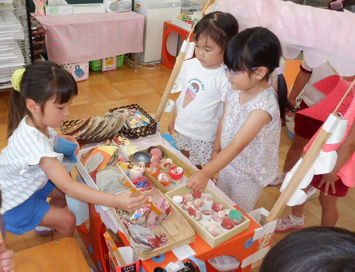 4歳児のお店屋さんごっこに3歳児がお客さんになって遊びに来ているところ