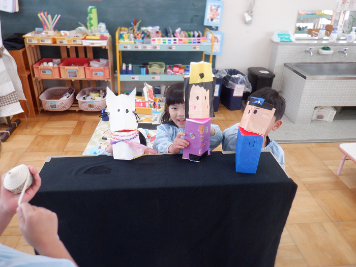 5歳児が紙パックでつくった人形で遊んでいるところ