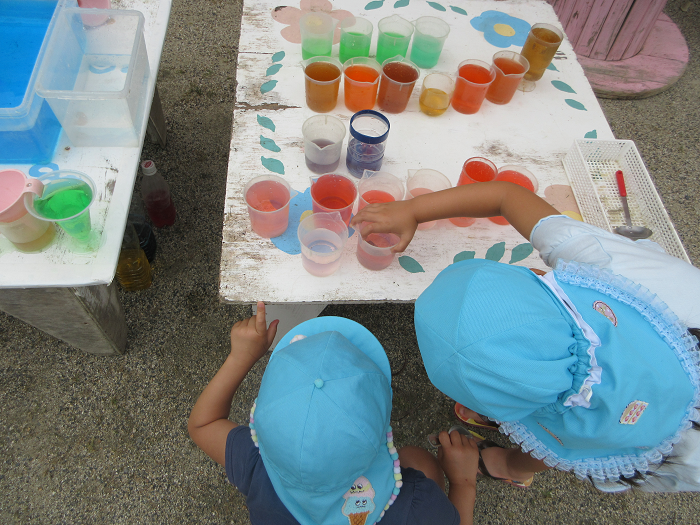 5歳児が色水を混色し、何色もつくって遊んでいるところ